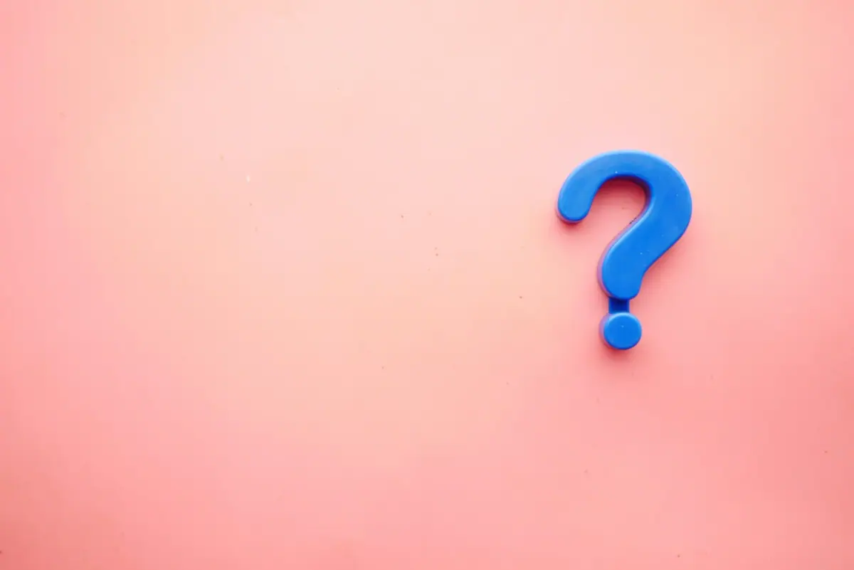 A blue question mark on a pink background.